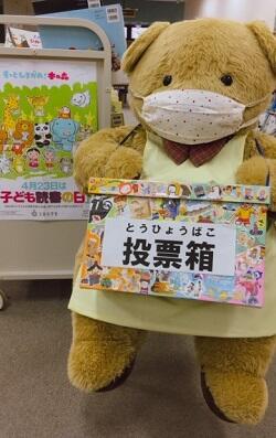 子ども読書の日イベントのお手伝いをしているクマたんの画像